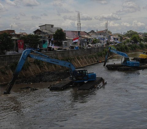 Pekerja menggunakan ekskavator untuk mengeruk material lumpur yang mengendap di Kali Ciliwung, Jakarta, Selasa (16/1/2023). Ancaman banjir masih terus membayangi Ibu Kota Jakarta, terlebih ketika musim penghujan tiba.