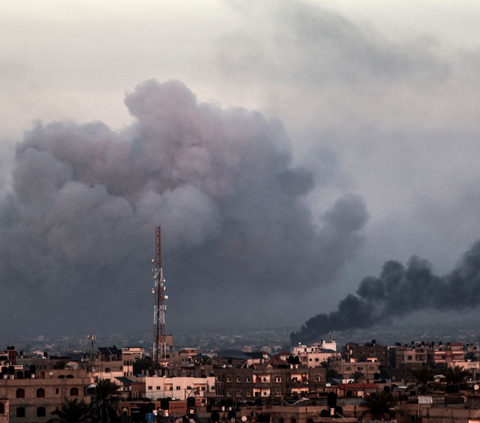 Foto yang diambil dari Rafah ini memperlihatkan kepulan asap yang membumbung tinggi di angkasa Kota Khan Yunis di Jalur Gaza selatan selama agresi Israel yang  melakukan pemboman pada 16 Januari 2024.<br>