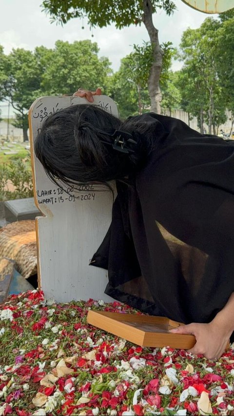 Kaneishia Yusuf sedang berlutut dan menangis di samping makam kekasihnya.<br>