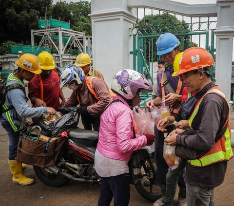 Sejumlah pekerja membeli makanan ketika jam istirahat di kawasan proyek pembangunan MRT Jakarta Fase 2A di Monas, Jakarta, Kamis (18/1/2024). Jumlah tenaga kerja Indonesia masih didominasi oleh sektor informal.