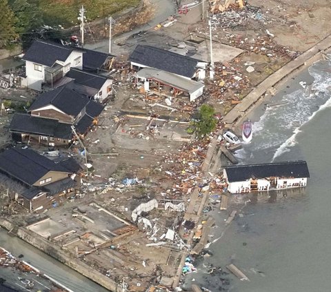 Pemandangan sebuah mobil dan rumah hanyut setelah terjadi gempa di pesisir Kota Noto, Prefektur Ishikawa, Jepang, pada Senin (1/1/2024). Gempa besar berkekuatan 7,5 magnitudo yang mengguncang Jepang telah memicu terjadinya gelombang tsunami.