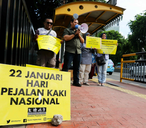 Aktivis dari Koalisi Pejalan Kaki menggelar aksi di kawasan Halte Tugu Tani, Jakarta, Senin (22/1/2024).<br>Mereka beraksi membawa dan membentangkan poster berwarna kuning dan berorasi di kawasan tersebut.<br>( Foto Liputan6.com / Herman Zakharia )