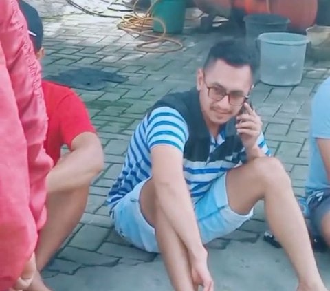 Selanjutnya, tampak seorang pria berbaju garis sedang duduk dengan ekspresi lemas sambil sibuk menelepon. 