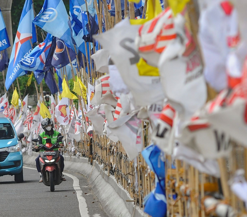 Alat peraga kampanye (APK) berupa bendera  partai politik semakin banyak terpasang pada pinggiran  jembatan layang Mampang, Jakarta, pada Selasa (23/1/2024).<br>(Foto merdeka.com / Arie Basuki)