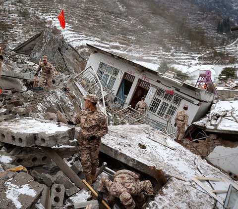 Pasukan militer China dan petugas penyelamat mencari korban hilang di antara reruntuhan bangunan setelah terjadi tanah longsor di Desa Liangshui, Kota Zhaotong, Yunnan, sebelah barat daya China, pada 22 Januari 2024. Foto: AFP