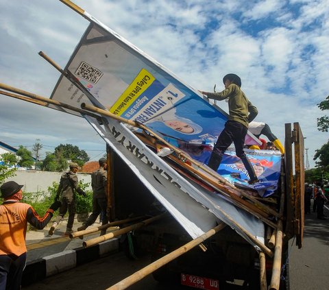 Petugas gabungan dari Panwaslu, Satpol PP, dan Polresta Depok menertibkan sejumlah alat peraga kampanye (APK) Pemilu 2024 di Jalan Margonda Raya, Kota Depok, Jawa Barat, Rabu (24/01/2024). 