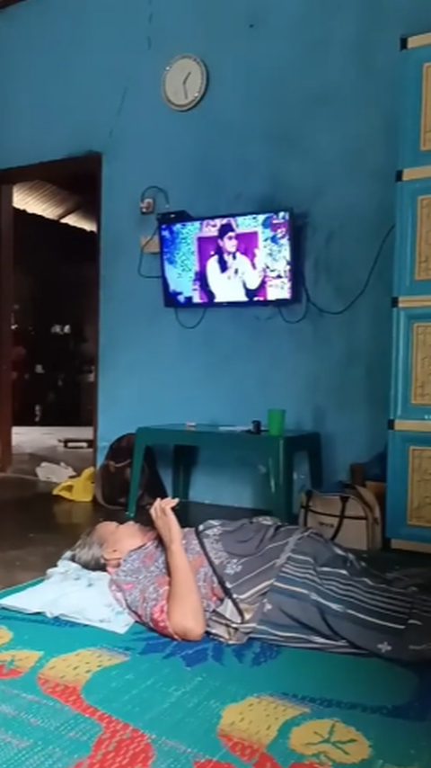 Pemilik akun TikTok mil_tum membagikan momen sang Ibu tengah bersantai sembari menonton televisi. <br>