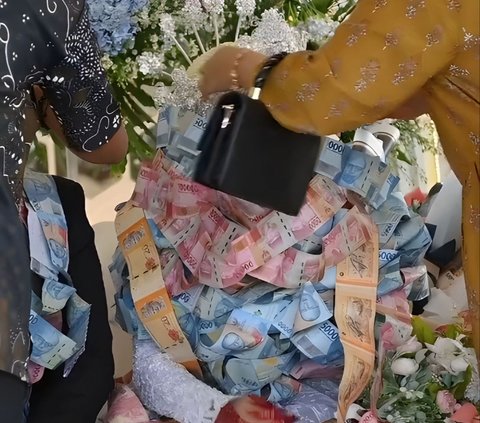 Viral Moment of Newlyweds in Madura Receiving Piles of Money Necklace as Wedding Gift Almost Covering Their Faces