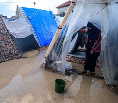 Guyuran hujan lebat menambah penderitaan warga Palestina yang mengungsi di Rafah, Jalur Gaza selatan, pada Sabtu (27/1/2024). Pasalnya, kamp pengungsian warga Palestina yang melarikan diri dari serangan Israel itu tampak terkepung genangan banjir.
