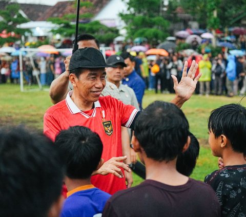 Presiden Joko Widodo atau Jokowi mengisi akhir pekan dengan bermain bola bersama anak-anak  di Lapangan Gamplong, Sumber Rahayu, Moyudan, Kabupaten Sleman, DIY, pada Sabtu (27/1/2024). Hujan deras yang mengguyur lokasi tersebut tak mengurangi keseruan Jokowi bermain bola.