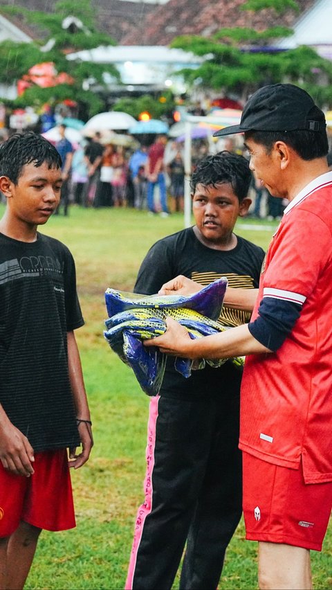 Jokowi juga menyerahkan jersey sepak bola kepada anak-anak yang bermain.<br>