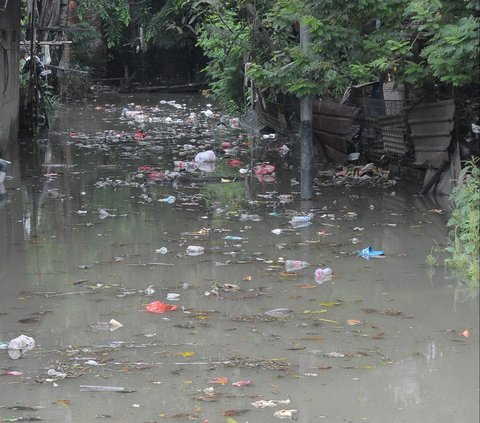 Sampah hanyut pada banjir yang menggenangi lingkungan RT 16/04, Kelurahan Rawa Terate, Kecamatan Cakung, Jakarta Timur, Rabu (31/1/2024). Foto: Merdeka.com/Imam Buhori
