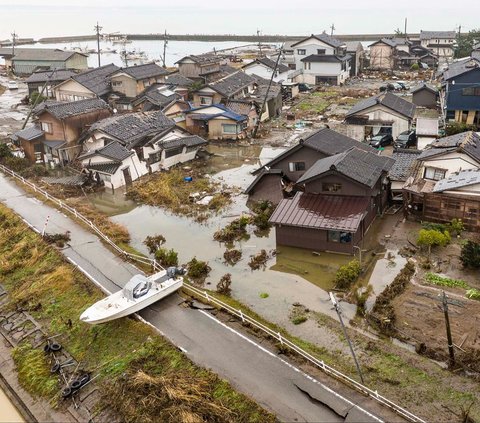 Sebuah kapal terdampar di dekat kawasan permukiman yang rusak parah setelah tersapu tsunami di pesisir Kota Suzu, Prefektur Ishikawa, Jepang, Rabu (3/1/2024). Terjangan tsunami yang dipicu gempa dahsyat 7,5 magnitudo telah membuat Kota Suzu porak-poranda.