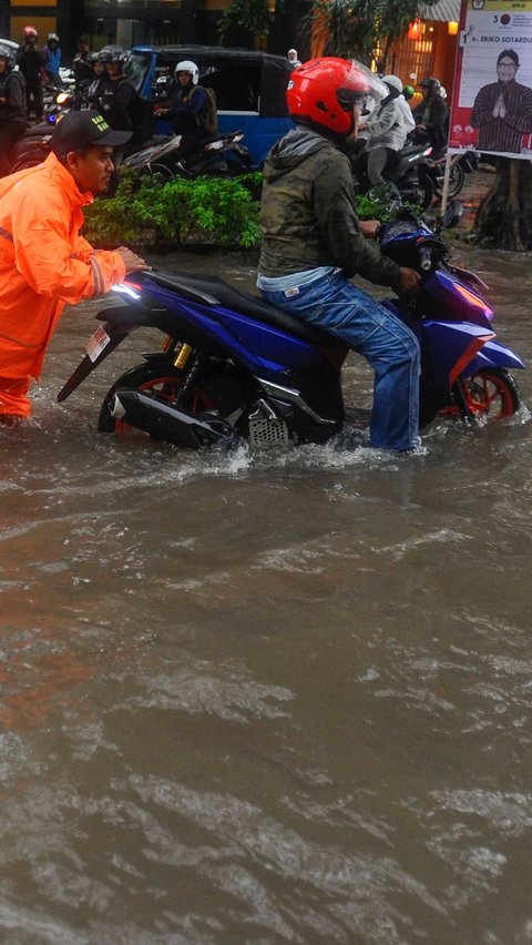 Beberapa kendaraan tampak mogok setelah nekat menerjang banjir.