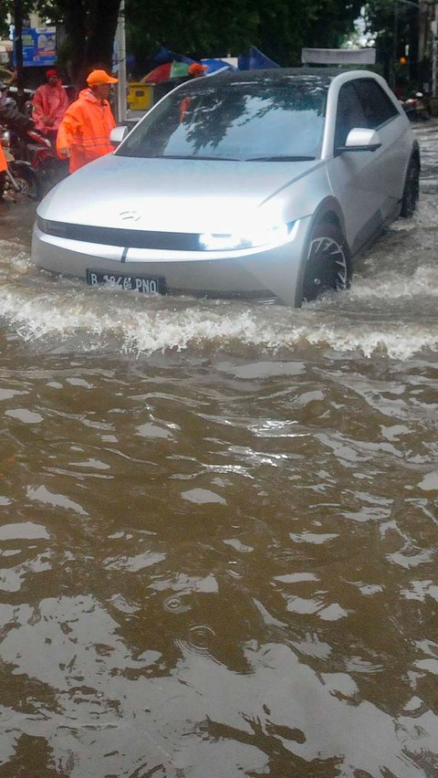 Sebuah mobil listrik menerjang banjir yang merendam Jalan Kemang Raya, Jakarta Selatan, Kamis (4/1/2024) sore.