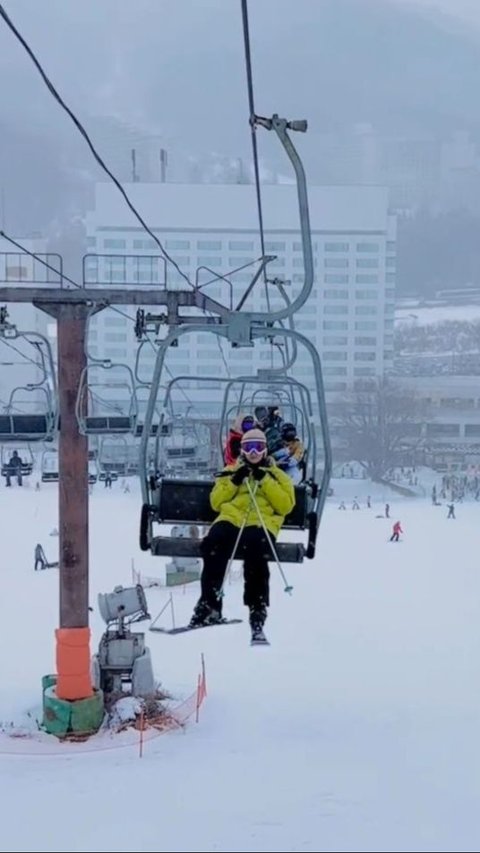 Natasha Rizky rides a cable car to a high place to go sledding.