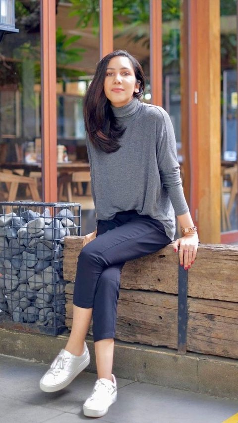 Potret sporty style ala Suhay, dengan turtleneck top, celana bahan, dan sneakers putih.