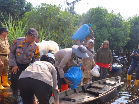 Usai Sosialisasi Pemilu, Kapolres Rohil Angkat Barang Warga Saat Evakuasi Korban Banjir
