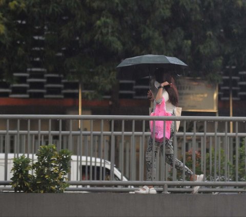Warga memakai payung saat hujan mengguyur di kawasan Sarinah, Jakarta, Sabtu (6/1/2024). Cuaca hari ini untuk DKI Jakarta dan sekitarnya diprediksi turun hujan yang disusul petir dan angin kencang pada sore hari.