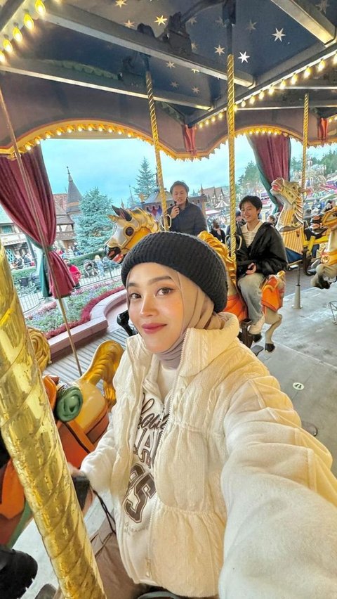 Putri Delina is seen enjoying a carousel ride.