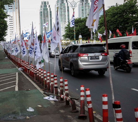 Ratusan alat peraga kampanye (APK) bendera partai politik terpasang di pembatas plastik jalur sepeda (stick cone) di kawasan Jalan Rasuna Said, Jakarta Selatan, Senin  (8/1/2024).