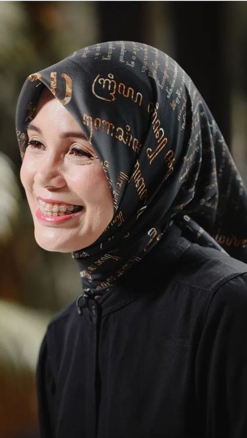 Portrait of Siti Atikoh wearing a Javanese Script patterned headscarf.