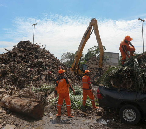 Sebuah alat berat ekskavator mengangkut sampah-sampah dari Kali Ciliwung untuk nantinya diolah ke mesin pencacah di tempat penyaringan sampah di TB Simatupang, Jakarta, Selasa (9/1/2024).