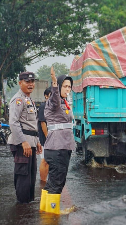 Aksi Perwira Polwan Rohil Atur Lalu Lintas saat Banjir Sambil Sosialisasi Pemilu