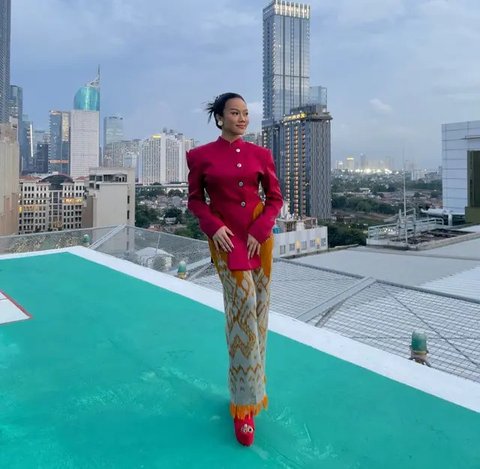 Yura Yunita tampil dengan atasan turtle neck putih lengan panjang, dipadukan bawahan kain merah bercorak putih. [@yurayunita]