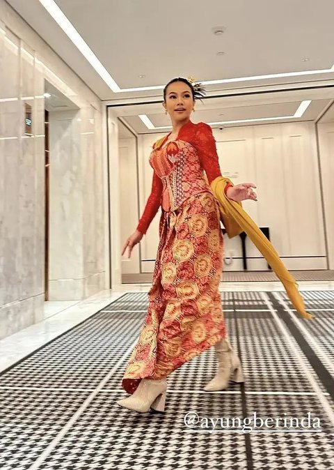 Yura Yunita tampil dengan atasan turtle neck putih lengan panjang, dipadukan bawahan kain merah bercorak putih. [@yurayunita]