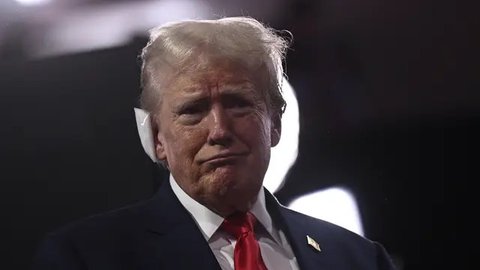 Ketika hendak meninggalkan panggung, Trump dilaporkan masih bisa mengepalkan tangan ke arah hadirin. (AP Photo/Evan Vucci)