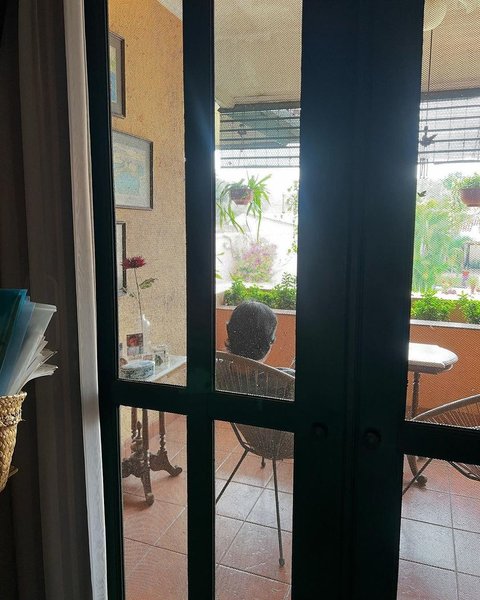 Tampak belakang, Ikang Fawzi terlihat duduk terdiam sendirian, melamun di teras rumah.&nbsp;