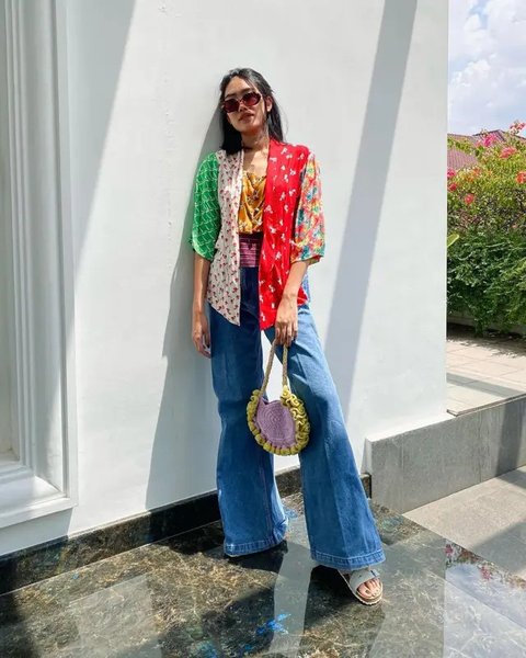 Alika Islamadina tampil dengan kebaya bermotif dipadukan celana putih putih panjang yang serasi dengan shoulder bag dan sneakersnya. [@alikaislamadina]