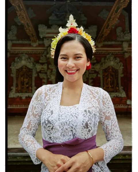 Kebaya Bali warna biru ini dipadukan dengan kain tenun Bali warna merah, lengkap dengan obi. [@raisa6690]