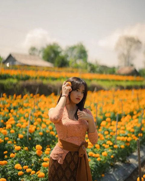 Kebaya Bali warna biru ini dipadukan dengan kain tenun Bali warna merah, lengkap dengan obi. [@raisa6690]