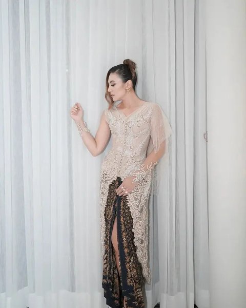 Putri Marino tampil anggun mengenakan kebaya modern brokat putih dipadukan kain batik sebagai bawahan yang juga dari Saptodjojokartiko. Melengkapi penampilan dengan anting-anting dari Tulola.