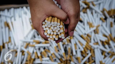 Petugas memperlihatkan rokok ilegal yang telah terkemas di Kantor Dirjen Bea Cukai, Jakarta, Jumat (30/9). Rokok ilegal ini diproduksi oleh mesin dengan total produksi 1500 batang per menit.