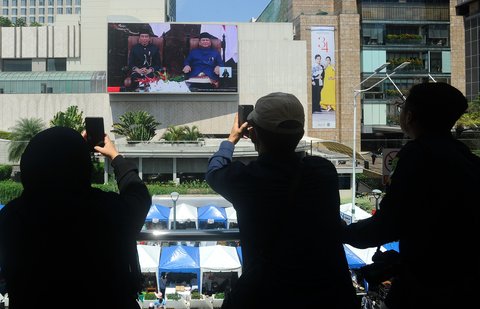 FOTO: Momen Warga Saksikan Prabowo Ucapkan Sumpah dan Janji sebagai Presiden Lewat Videotron