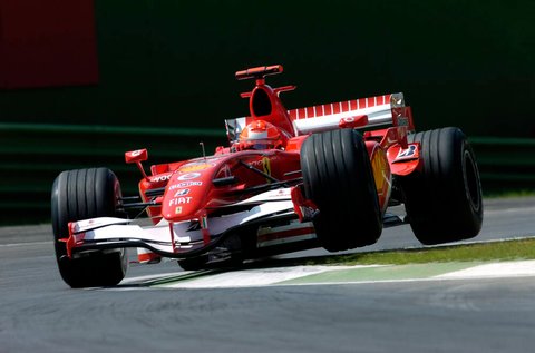 Michael Schumacher mengemudikan Ferrari 248 F1 dalam perlombaan.