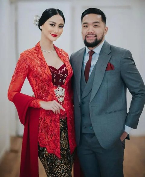 Terlihat Jessica Mila mengenakan kebaya peach dan ulos warna hijau sage. Sedangkan Yakub tampil dengan setelan jas abu dan warna peach senada kebaya sang istri.