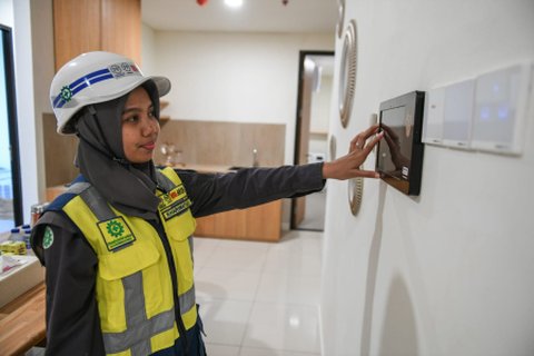 Pekerja mencoba alat pengatur rumah pintar (smart home control) di unit Rusun ASN di IKN.