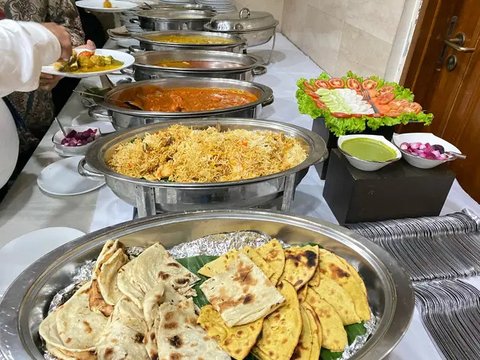 Seorang pedagang kaki lima menyiapkan makanan saat seorang pria makan di sebuah pasar grosir sayuran di Guwahati, India, Rabu (1/2/2023). Pemerintah Perdana Menteri India Narendra Modi mening