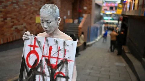 Seorang seniman tampil untuk memberikan penghormatan di sebuah gang di kawasan hiburan malam Itaewon yang populer di Seoul pada tanggal 29 Oktober 2024. (Shin Yong-ju/AFP)