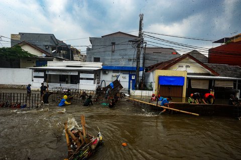 FOTO: Aksi Pekerja Berjibaku Perbaiki Tanggul Jebol yang Bikin Ratusan Rumah di Tangerang Selatan Dikepung Banjir