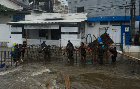 FOTO: Aksi Pekerja Berjibaku Perbaiki Tanggul Jebol yang Bikin Ratusan Rumah di Tangerang Selatan Dikepung Banjir