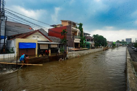 FOTO: Aksi Pekerja Berjibaku Perbaiki Tanggul Jebol yang Bikin Ratusan Rumah di Tangerang Selatan Dikepung Banjir