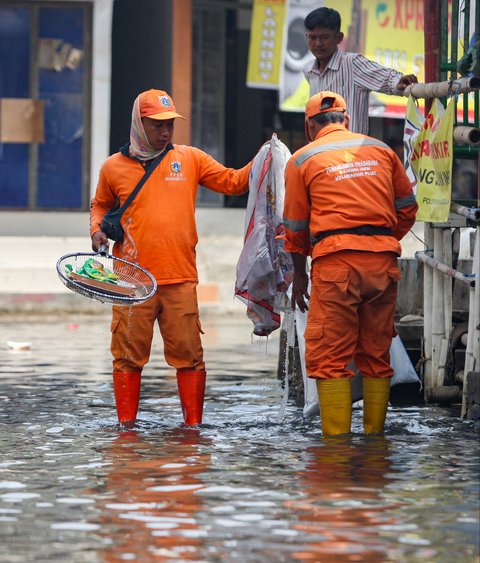 FOTO: Aksi Petugas PPSU Berjibaku Bersihkan Sampah Banjir Rob di Muara Angke