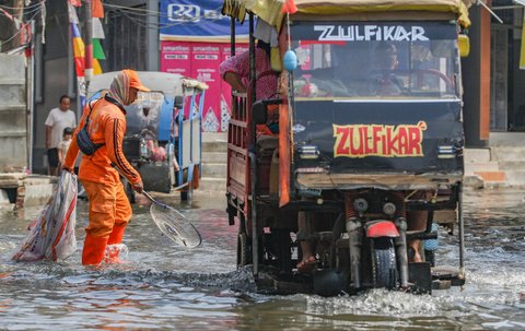 FOTO: Aksi Petugas PPSU Berjibaku Bersihkan Sampah Banjir Rob di Muara Angke