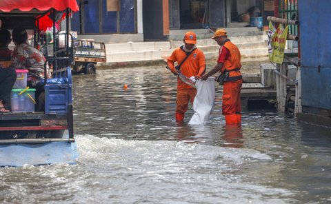 FOTO: Aksi Petugas PPSU Berjibaku Bersihkan Sampah Banjir Rob di Muara Angke