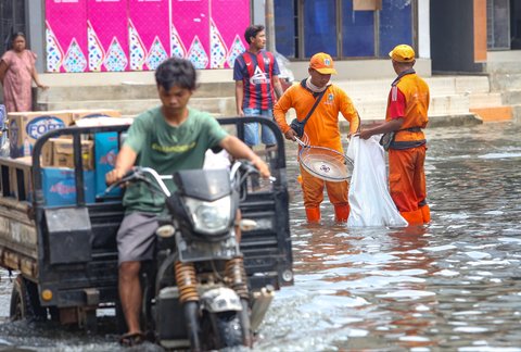 FOTO: Aksi Petugas PPSU Berjibaku Bersihkan Sampah Banjir Rob di Muara Angke